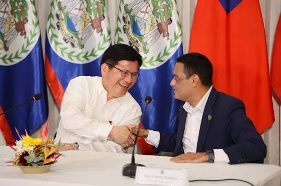 Francis Fonseca shaking hands across a signing table with a counterpart, the flags of Belize and the Republic of China (Taiwan) behind them.